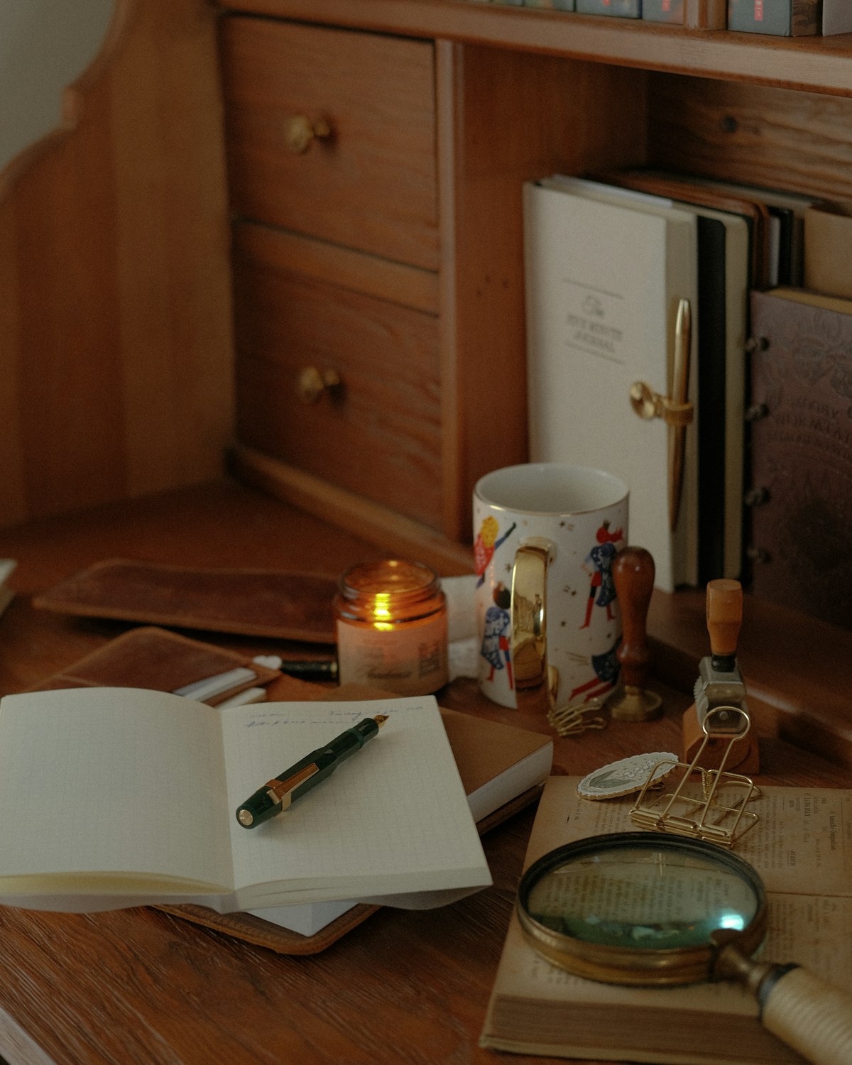Open notebook and pen on a pale wooden desk