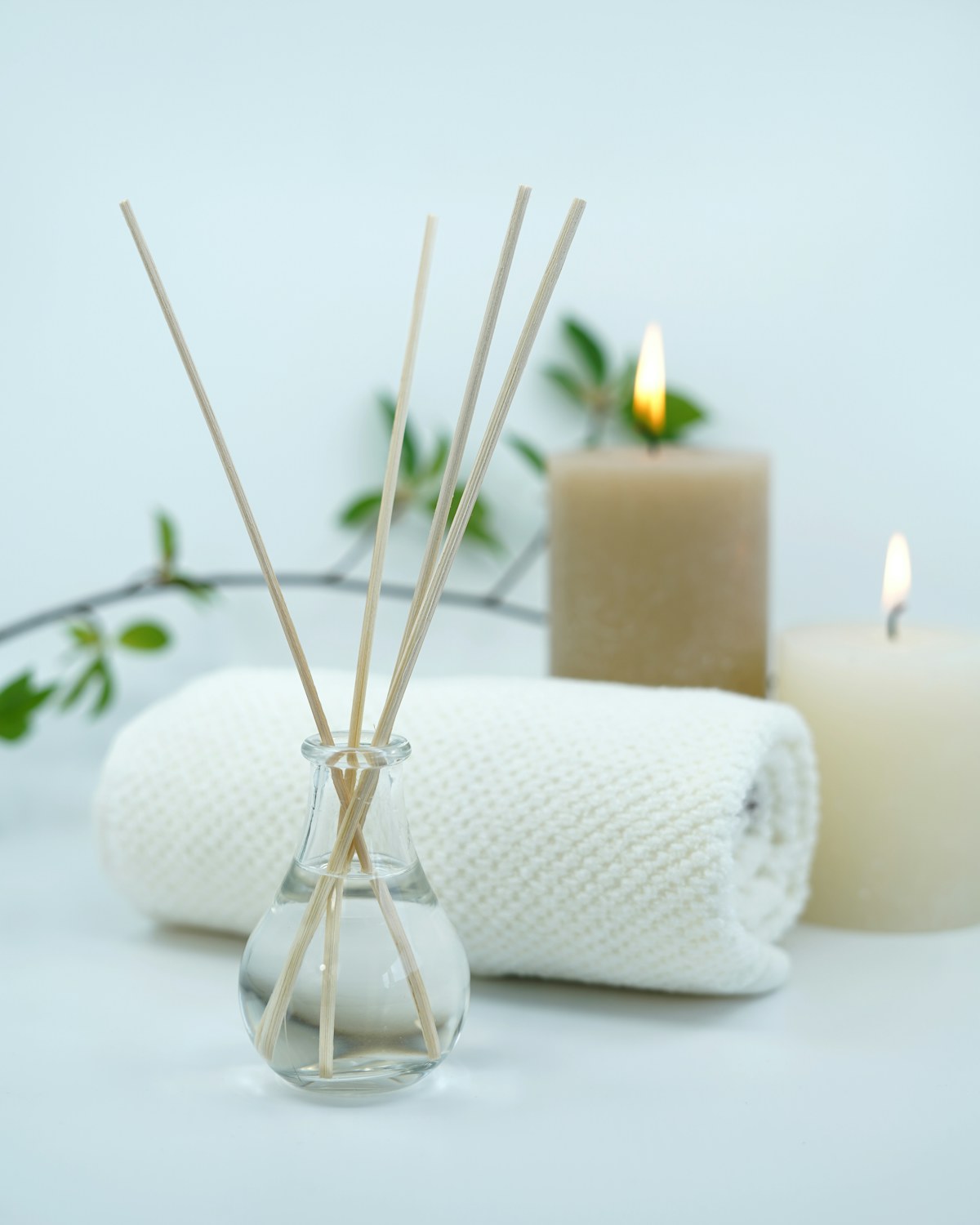 Folded white towels and a candle on wood